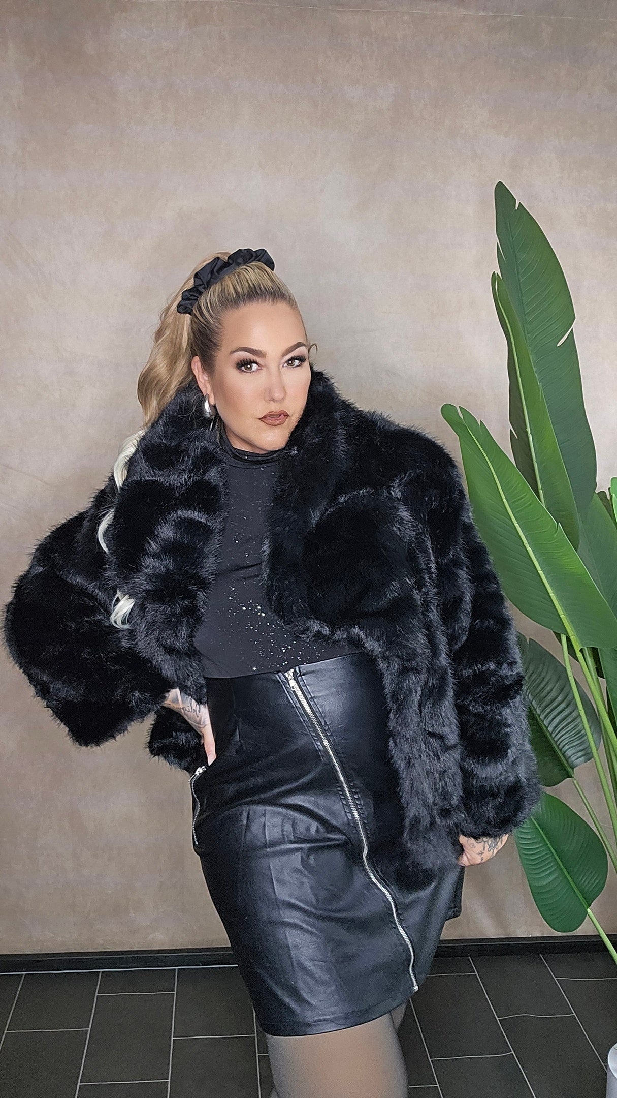 Schwarze Fake Fur Jacke Plus Size - Ganzkörperansicht mit Leder-Rock kombiniert, zeigt perfekten Sitz für große Größen