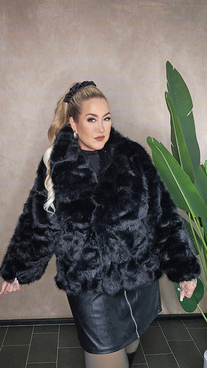 Luxuriöse schwarze Kunstfell-Jacke Plus Size - Nahaufnahme zeigt flauschige Textur und eleganten Look perfekt für kurvige Frauen